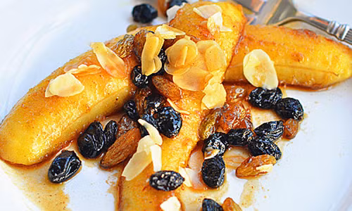 Cho chuối ra đĩa, trang trí thêm bằng hạt hạnh nhân. Vậy là bạn đã hoàn thành món chuối nướng rượu rum thơm ngon rồi.