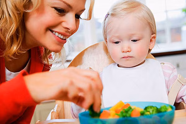 Ăn cùng con. Trẻ em thường không thích ăn những gì là của mình, có trong đĩa của mình mà thích ăn những gì của người khác, nhất là của bố mẹ. Vậy thì thay cho việc lấy khẩu phần thịt cho con, hãy lấy rau vào đĩa của mình và cùng ăn chung với con. Thấy mẹ ăn ngon lành, chắc chắn, trong vài giây, bé cũng muốn ăn như mẹ.