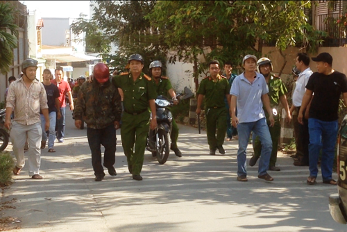 Thượng tá Sâm (quân phục cảnh sát) đưa đối tượng Long (mũ bảo hiểm đỏ) rời hiện trường.