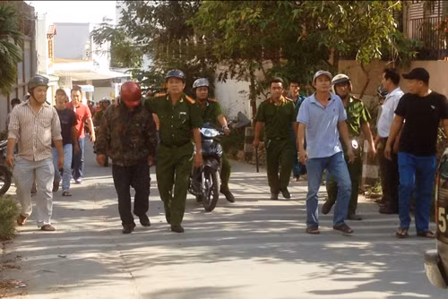 Thượng tá Sâm (quân phục cảnh sát) đưa đối tượng Long (mũ bảo hiểm đỏ) rời hiện trường.