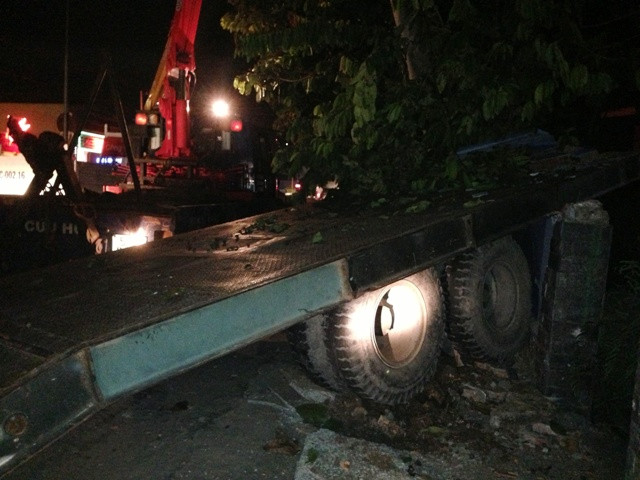 Hiện trường chiếc sơmi rơ-moóc tông gãy trụ điện trung thế và tường nhà dân.