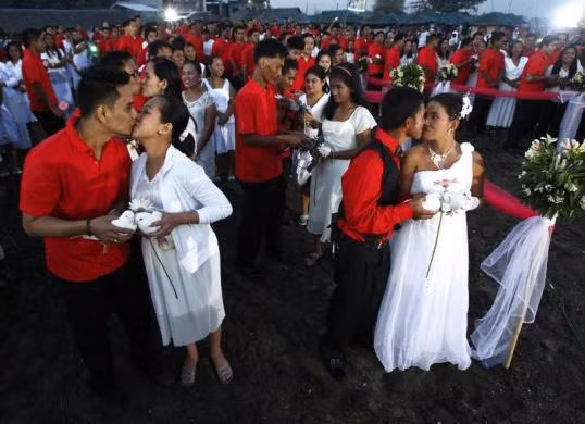 Các cặp đôi mới cưới trao nhau nụ hôn say đắm trong lễ cưới tập thể ở thị trấn Rosario, thành phố Cavite, miền nam Manila ngày 13/2, một ngày trước lễ Valentine.