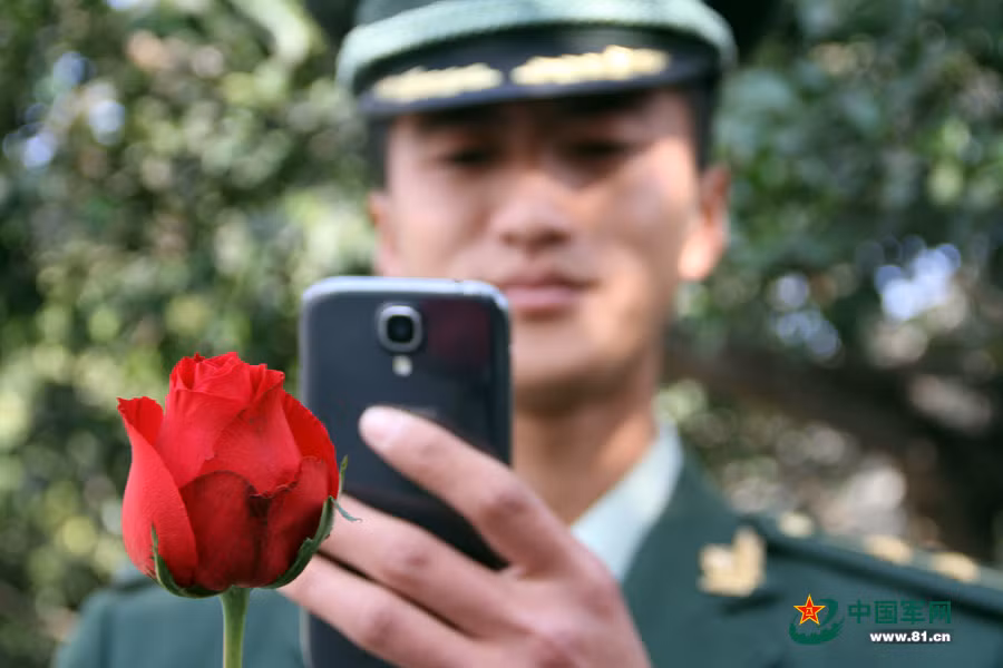 Một sĩ quan cảnh sát vũ trang ở tỉnh Tứ Xuyên phía tây nam Trung Quốc chụp ảnh bông hồng gửi bạn gái nhân ngày lễ tình nhân Valentine.