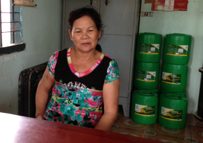 Bà Lan kể lại diễn biến vụ cướp và phía sau lưng bà là nơi viên đạn bị bắn trúng thùng nhớt.