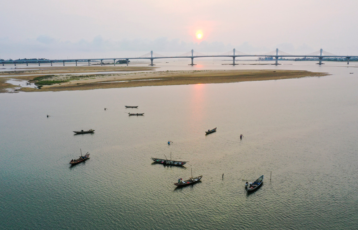 Từ buổi sáng sớm, người dân ở xã Nghĩa Phú, TP Quảng Ngãi đã ngâm mình trong nước cào don (loài nhuyễn thể sống ở gần cửa biển) để mưu sinh bên những cồn cát.