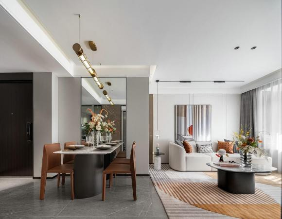 Màu sắc của phòng khách trong ngôi nhà là toàn bộ màu trắng ấm áp, với một số điểm nhấn màu cam sáng, sống động và phong cách. Ghế sofa hình vòng cung với một tay vịn giải phóng nhiều không gian hơn.