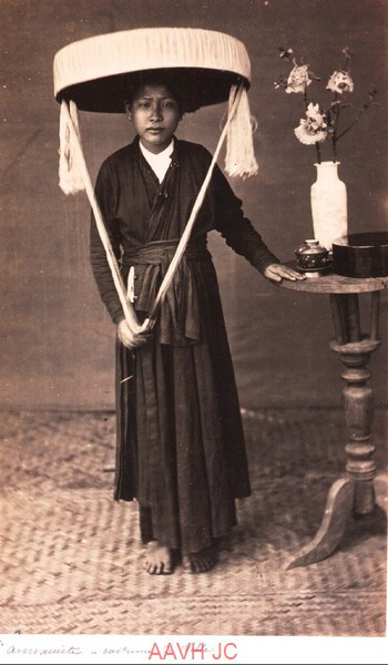 Cô gái mặc áo tứ thân, đội nón quai thao.