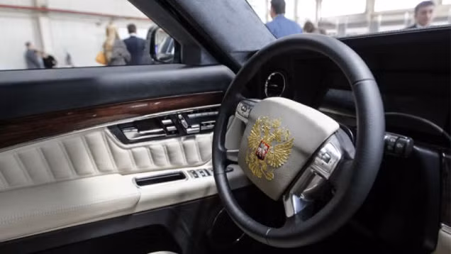 Tay lái mang quốc huy của Nga hình con đại bàng đang dang cánh. Cửa xe đều được lắp kính chống đạn và tối màu khi nhìn từ ngoài vào.