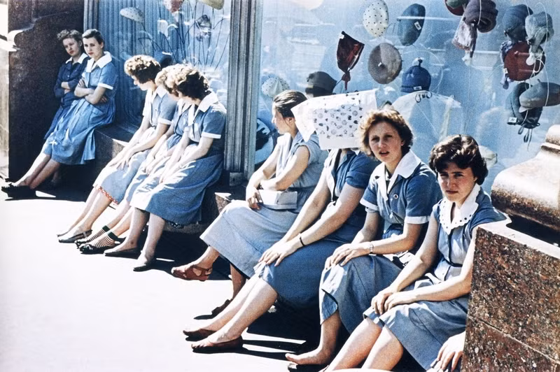 Một nhóm thiếu nữ trẻ Moscow ngồi nghỉ trước tủ kính bày hàng.