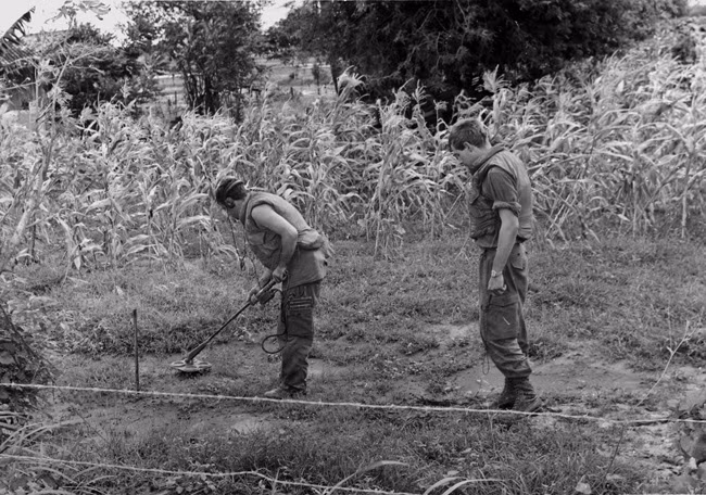 Hai binh sĩ New Zealand sử dụng máy dò tìm bom mìn tại khu vực gần làng Hòa Long năm 1969.