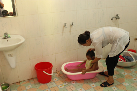 Nhân viên Trung tâm Bảo trợ Xã hội Thụy An chu đáo tắm sạch sẽ cho từng em.