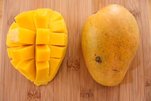 Xoài cắt miếng. Một cốc nhỏ xoài vàng óng ánh có hơn 100kalo. Hầu hết năng lượng của xoài là do hàm lượng đường tự nhiên cao. Ngoài vị ngọt dịu của xoài chín, bạn sẽ nhận được 3g chất xơ, vitamin A và vitamin C trong mỗi phần xoài. Ăn xoài là cách giúp bà bầu có hệ miễn dịch khỏe mạnh.