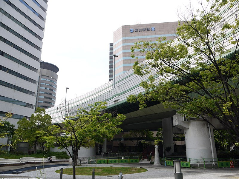 Năm 1983, chủ nhân tòa nhà từ chối nhượng khu đất để làm đường nhưng sau 5 thương lượng, chính quyền Osaka và chủ tòa nhà đã đạt được thỏa thuận như hiện tại.