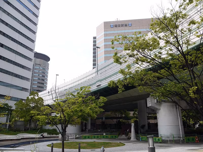 Năm 1983, chủ nhân tòa nhà từ chối nhượng khu đất để làm đường nhưng sau 5 thương lượng, chính quyền Osaka và chủ tòa nhà đã đạt được thỏa thuận như hiện tại.