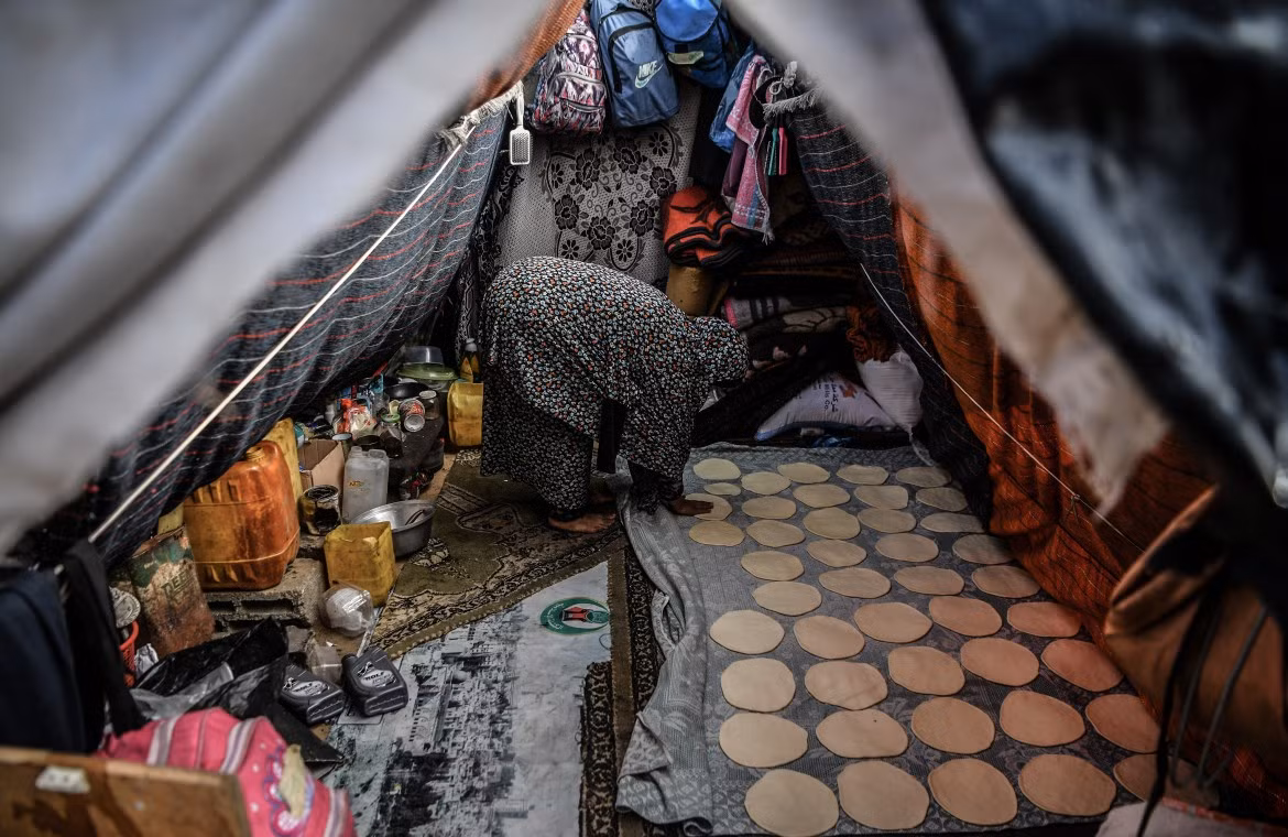 Người phụ nữ lám bánh mì trong túp lều tạm bợ.