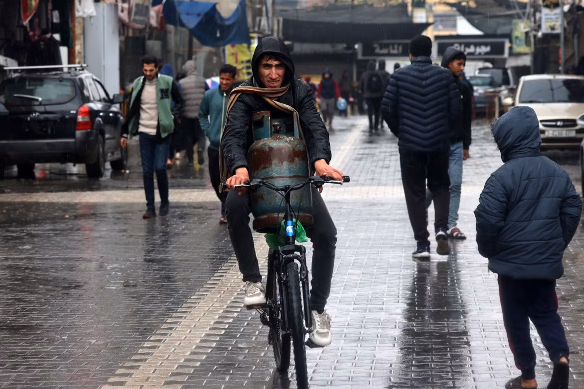 Người đàn ông vận chuyển bình ga bằng xe đạp ở Rafah.