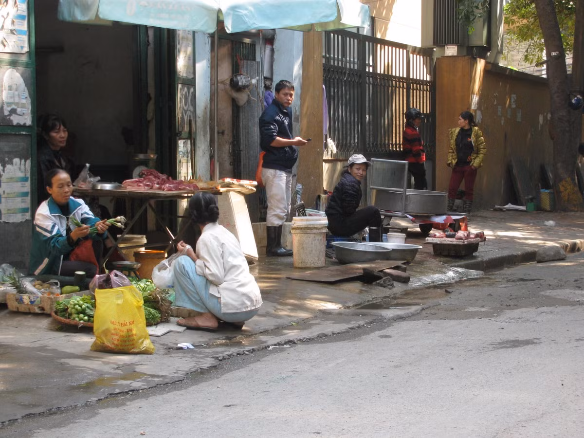 Trong ảnh là chợ họp xuyên trưa trên phố Pháo Đài Láng (quận Đống Đa). Theo nghị định số 34 quy định xử phạt vi phạm hành chính trong lĩnh vực giao thông đường bộ, hành vi chiếm dụng đường phố để kinh doanh dịch vụ ăn uống; bày bán hàng hóa; kinh doanh buôn bán vật liệu xây dựng; sửa chữa hoăc rửa xe… có thể bị phạt từ 20 đến 30 triệu đồng. Hành vi họp chợ, mua, bán hàng hóa trên đường bộ ngoài đô thị cũng bị phạt từ 300.000 đồng đến 500.000 đồng.