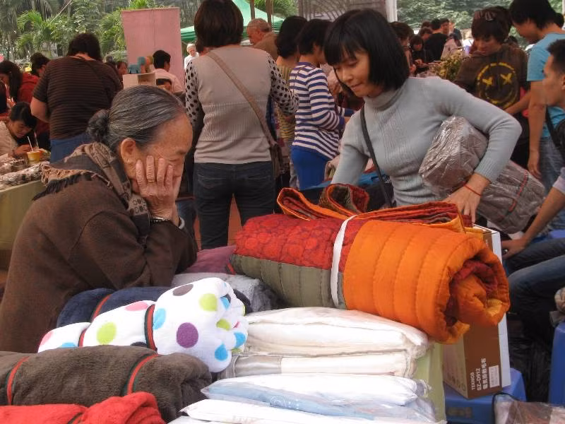 Cụ bà "tạo dáng" bên quầy chăn nỉ.