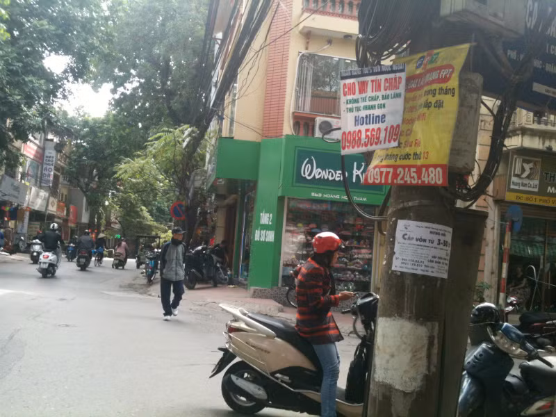 Nhiều quảng cáo vẫn ngày ngày "đung đưa" trên cây cột điện đầu phố Vĩnh Phúc (quận Ba Đình).