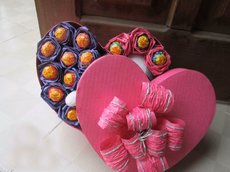 Hộp kẹo gấu bông là mẫu quà tặng độc đáo, là sự kết hợp tinh tế và đáng yêu giữa hoa, những chiếc kẹo mút ngọt ngào và cả những chú gấu bông xinh xắn, đảm bảo món quà sẽ làm cho nửa kia của các đấng mày râu vô cùng hạnh phúc! Món quà này giá rất mềm ở mức 100 - 150 nghìn đồng/hộp.