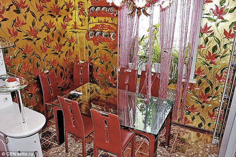 Phòng ăn được phủ một lớp tường ánh vàng có họa tiết hoa đỏ nổi bật.