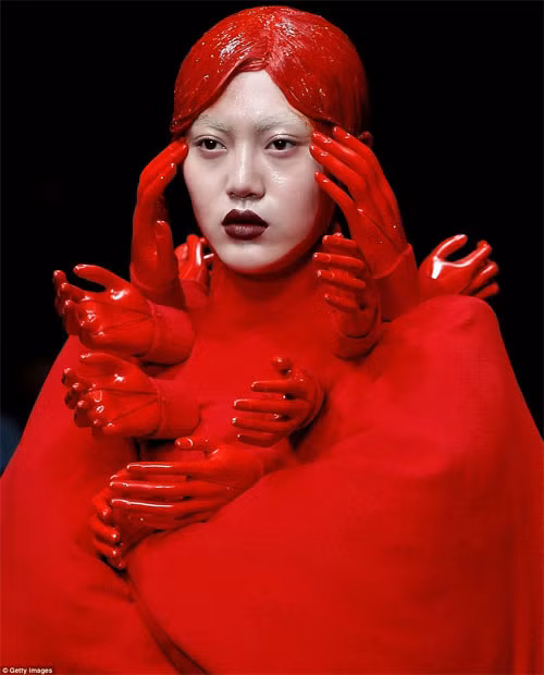 Những người mẫu trên sàn diễn chẳng khác nào những cô búp bê được bao phủ bởi những lớp vải hay cao su đỏ thắm, tạo cảm giác bi tráng và hơi rùng rợn.