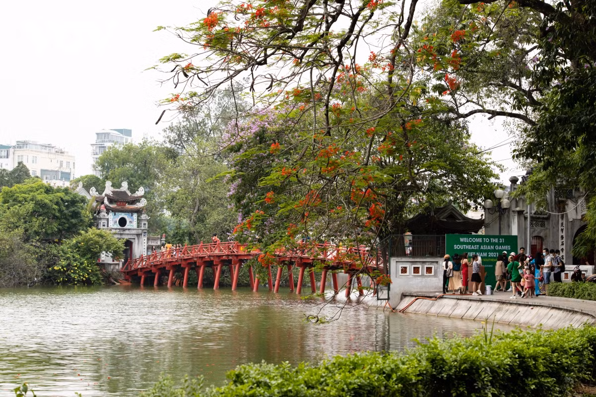 Cầu Thê Húc dường như rực rỡ hơn khi xuất hiện cùng màu hoa phượng đỏ.