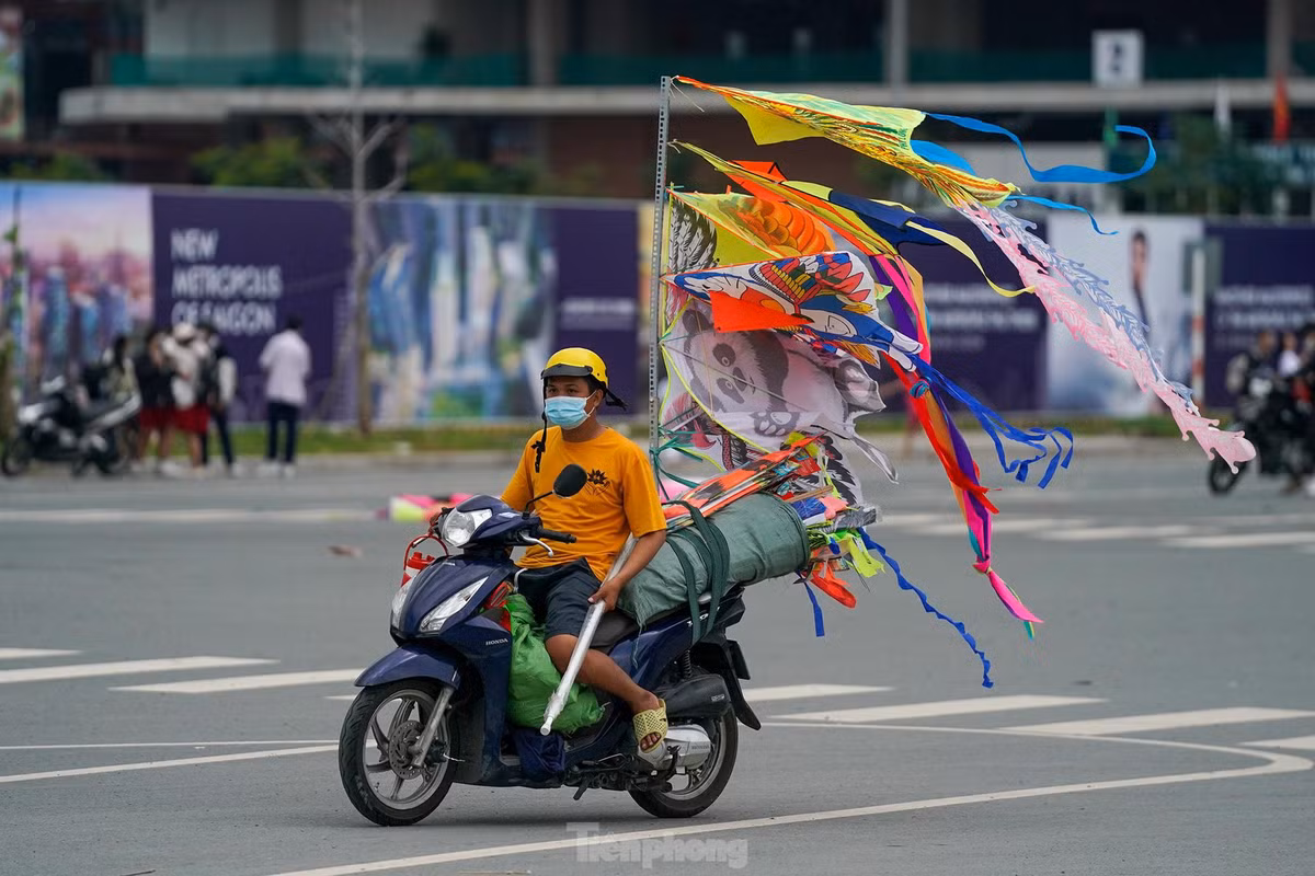 Những người bán diều di chuyển trong điều kiện diều vẫn treo trên xe, bay phấp phới, rất dễ gây va chạm với người đi đường.