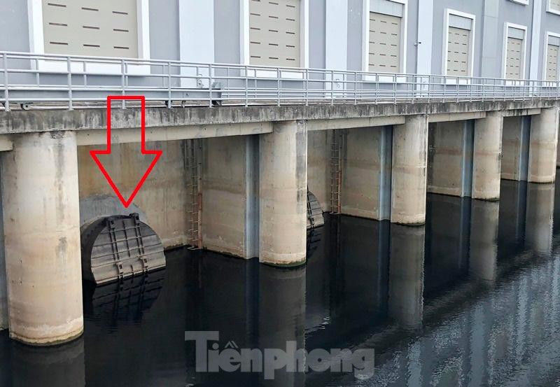 Các miệng xả nước của máy bơm (mũi tên) ra phía kênh dẫn chảy về sông Đáy chiều qua đóng kín. Lý giải cho nguyên nhân vì sao trạm bơm không hoạt động khi nước sông Nhuệ đang dâng cao, đơn vị quản lý trạm bơm thuộc Sở NN&amp;PTNN Hà Nội cho biết, do lượng nước đổ về hồ chứa không đủ để trạm bơm hoạt động.