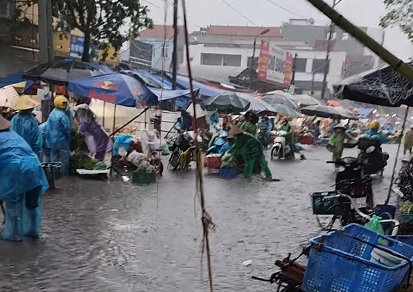 Khu vực chợ Thổ Tang (Vĩnh Phúc) ngập sâu khoảng 0,15 m, ảnh hưởng đến việc buôn bán của người dân. Đến sáng 24/5, mưa lớn vẫn trút xuống khu vực này. (Ảnh: Thu Lê)