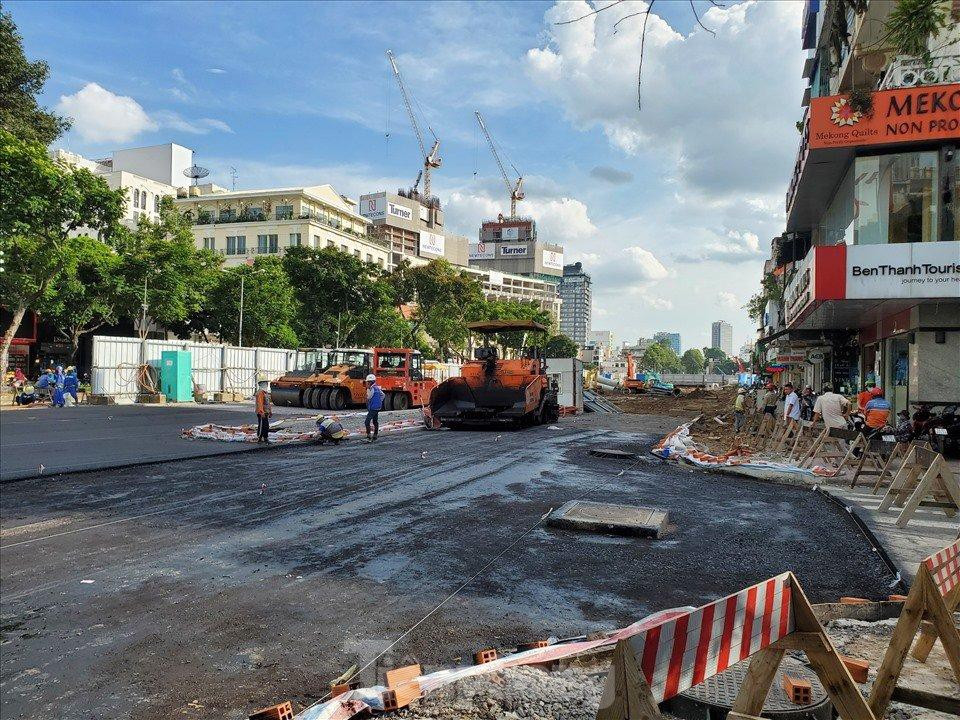 Rào chắn xung quanh đã được gỡ bỏ, thay thế bằng rào gỗ để hạn chế người dân lưu thông vào khu vực đang thi công thảm mặt đường.