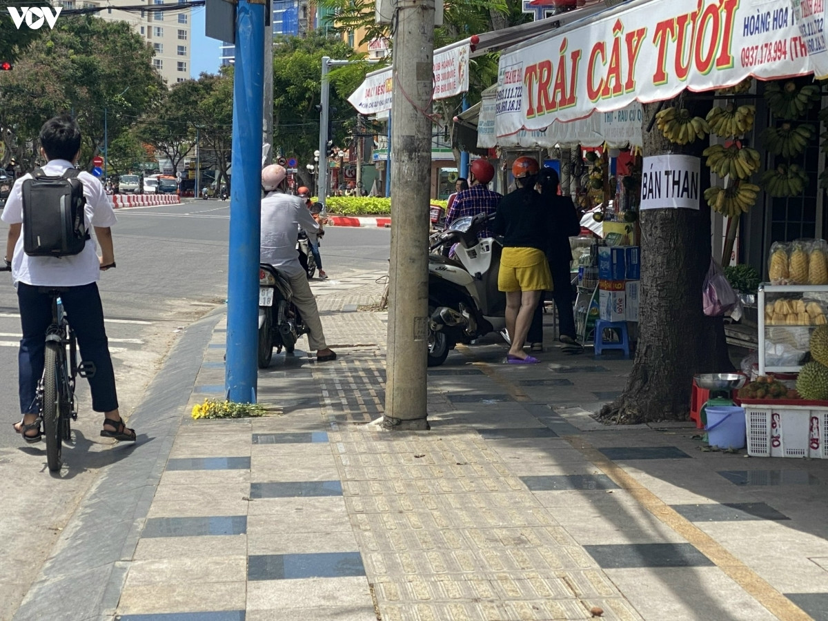 Cột điện nằm chắn giữa lối đi dành cho người đi bộ trên góc ngã tư Võ Thị Sáu - Hoàng Hoa Thám