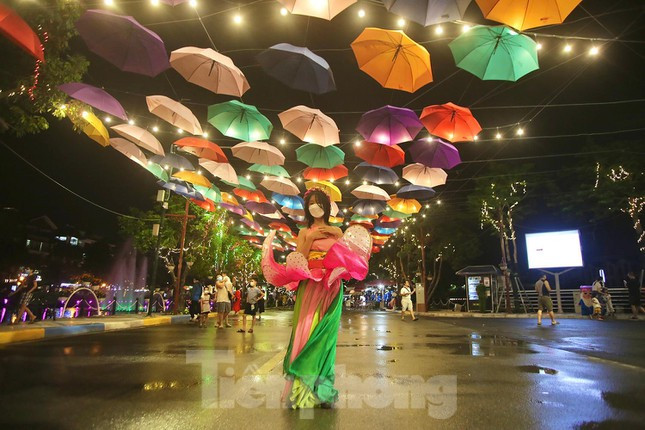 Một thiếu nữ tạo dáng chụp ảnh với những chiếc ô gắn trên cao thuộc khuôn viên phố đi bộ Trịnh Công Sơn. Ảnh: Duy Phạm