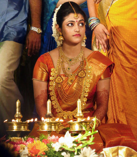 Trang sức trên người cô dâu gồm: 4 dây chuyền thủ công tinh xảo, nhẫn, 16 vòng đeo tay, một chiếc thắt lưng, hoa tai và một hòn đá nạm mảnh trên trán cho phù hợp với đường viền trên váy.