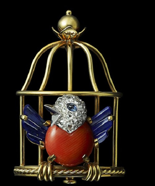 Chiếc trâm cài hình chú chim mới được tháo cũi sổ lồng này được làm từ đá quý ba màu của Pháp.