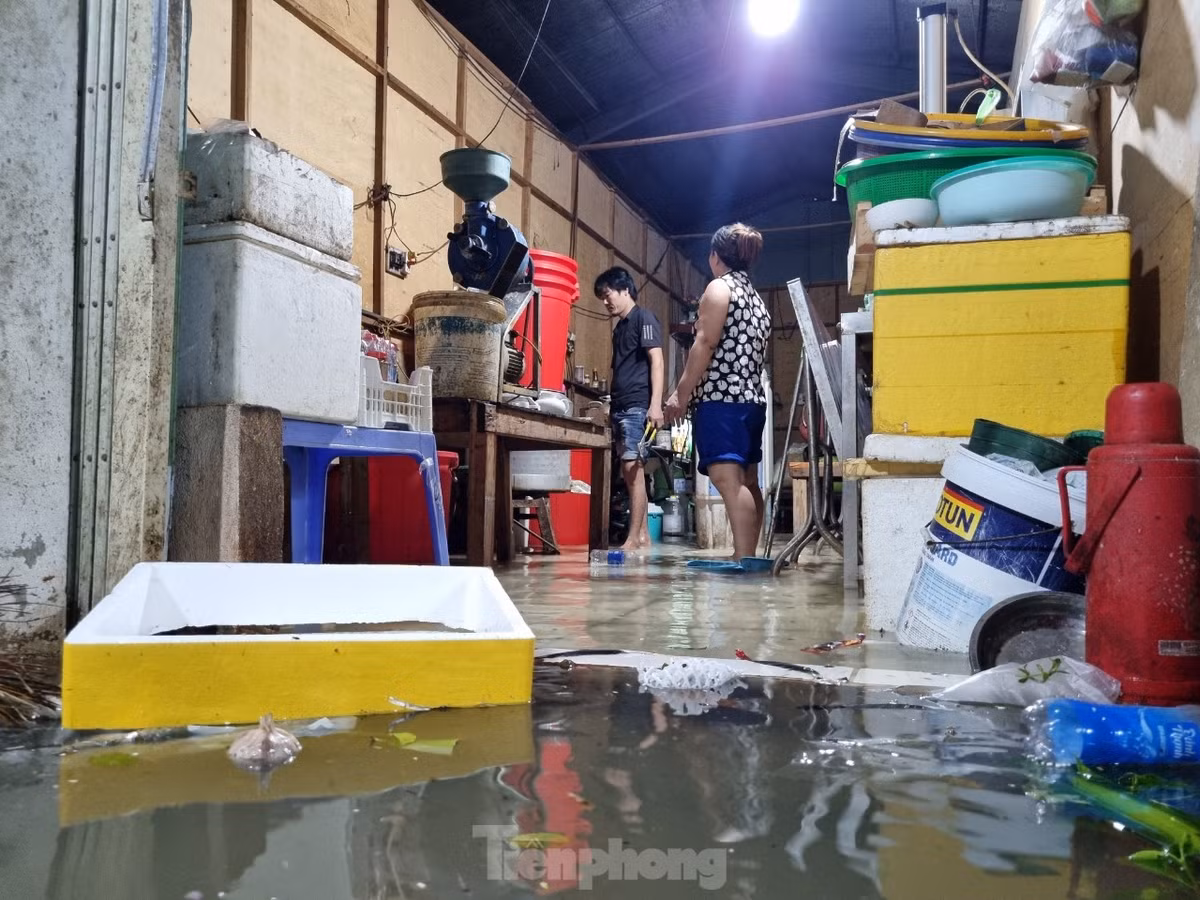 Nước tràn vào nhà dân rất nhanh. Các hộ dân tất bật cả tối dọn đồ đạc, kê gác những thiết bị điện lên để khỏi bị chập chạm.