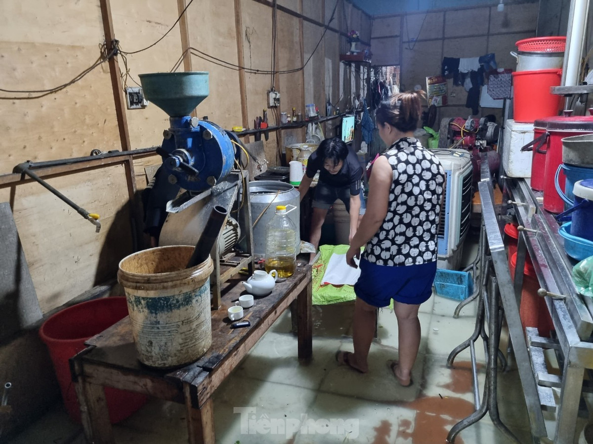 Xưởng làm đậu khuôn của một gia đình tại đường Phong Bắc 15 đã bị nước bủa vây. Cả nhà sốt sắng tháo máy móc, kiếm đồ đạc ghép thành giá đỡ để kê lên cao. Tuy nhiên mưa không ngớt, nên trong đêm khó có thể thoát cảnh ngâm nước.