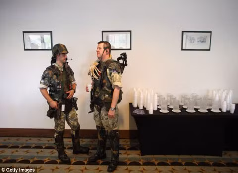 Những người tham dự cuộc gặp trong trang phục người lính đang uống nước trong giờ nghỉ.