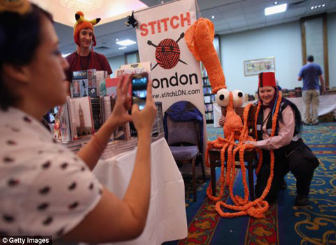 Một phụ nữ đang chụp hình cùng chú mực khổng lồ, dài 8m Plarchie, được làm hoàn toàn bằng túi nhựa.