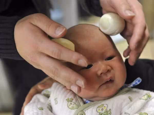 Massage trứng cho trẻ. Trong bức ảnh này, chúng ta thấy một người cha cho con mình một massage đầu với trứng sau khi cắt tóc tại một trung tâm chăm sóc ở Hợp Phì, tỉnh An Huy, Trung Quốc. Theo niềm tin truyền thống của Trung Quốc, đi cắt tóc vào ngày thứ hai của tháng âm lịch của Trung Quốc có thể mang lại may mắn cho các bé.