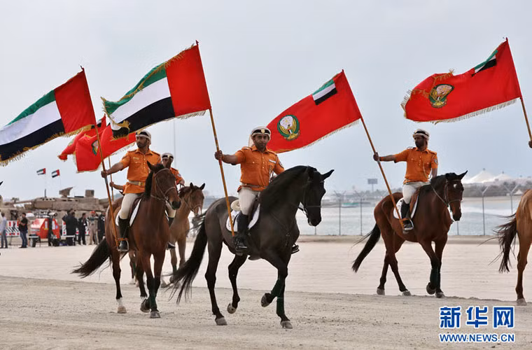 Dưới nền nhạc của đội quân nhạc, các kỵ binh vận quân phục bộ lạc cổ xưa của UAE cưỡi ngựa tiến vào quảng trường.
