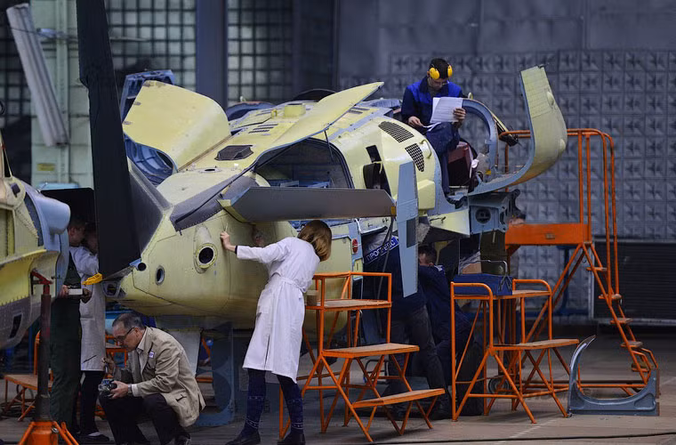 Các công nhân nhà máy đang lắp ráp thiết bị vào bên trong trực thăng.