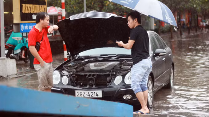Tại các tuyến phố như Liễu Giai, Phan Kế Bính, Hoàng Văn Thái…, nhiều đoạn nước ngập sâu hơn nửa mét khiến không ít ôtô, xe máy bị chết máy. Trong ảnh là 1 chiếc ô tô bị chết cứng máy khi cố vượt qua khu vực nước ngập sâu.