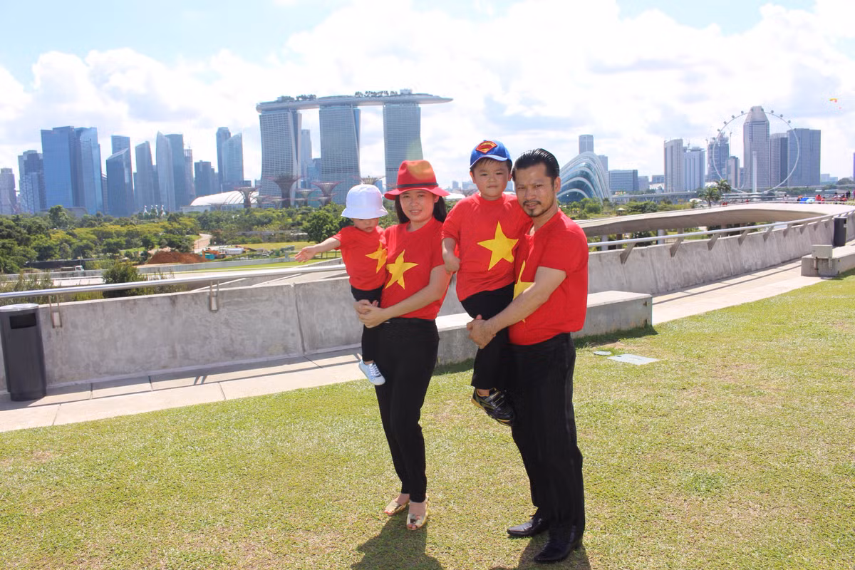 Màu áo đỏ thắm cũng thể hiện tình cảm gia đình thắm thiết, hạnh phúc của gia đình doanh nhân.