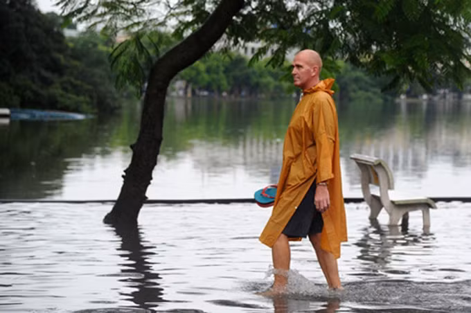 Cảm giác lạ. Một du khách nước ngoài lội trên bờ hồ Hoàn Kiếm. Ảnh: VOV