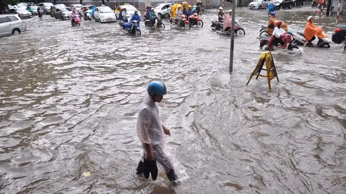 Xách giày... tìm lối đi, tại ngã tư Hai Bà Trưng - Hàng Bài (Hà Nội). Ảnh: Tuổi Trẻ