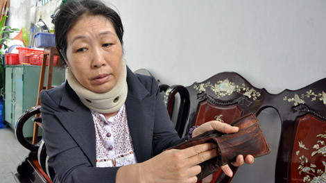 Vợ ông Phạm Duy Phúc (tài công bị nạn) với chiếc ví của chồng - nơi bà phát hiện tờ quyết định điều động sử dụng canô bị chìm trên biển Cần Giờ.