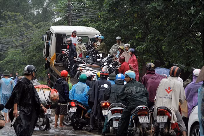 Mưa kéo dài khiến nhiều tuyến phố Hà Nội chìm trong biển nước, việc đi lại của người dân gặp nhiều khó khăn. Ở những đoạn đường nước ngập sâu, ngay lập tức xuất hiện những... “vị cứu tinh”. Ảnh: VTC