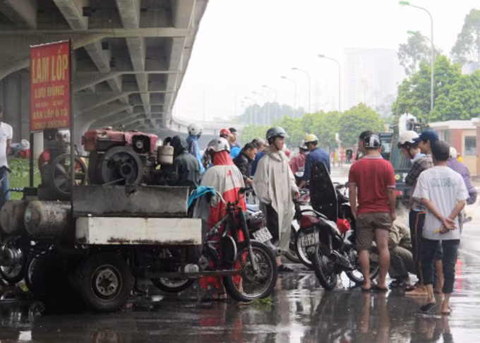 Rất nhiều người phải "cầu cứu" dịch vụ làm lốp di động. Ảnh: Người Lao Động
