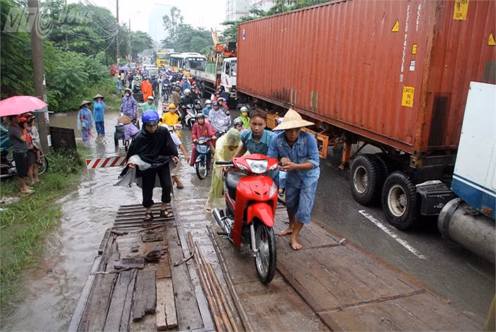 Những chiếc xe tải bỗng trở thành xe cứu hộ đưa người dân qua đoạn ngập nặng gần 1 km từ cổng cơ sở bệnh viện K đến cổng Viện quân y 103 (Hà Đông, Hà Nội). Ảnh: VTC